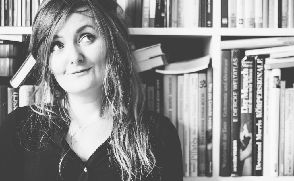 Bloggerin Miriam vorm vollgestopften Bücherregal